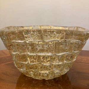 May include: A clear glass bowl with a textured, woven design. The bowl has a gold-colored metallic finish on the inside.