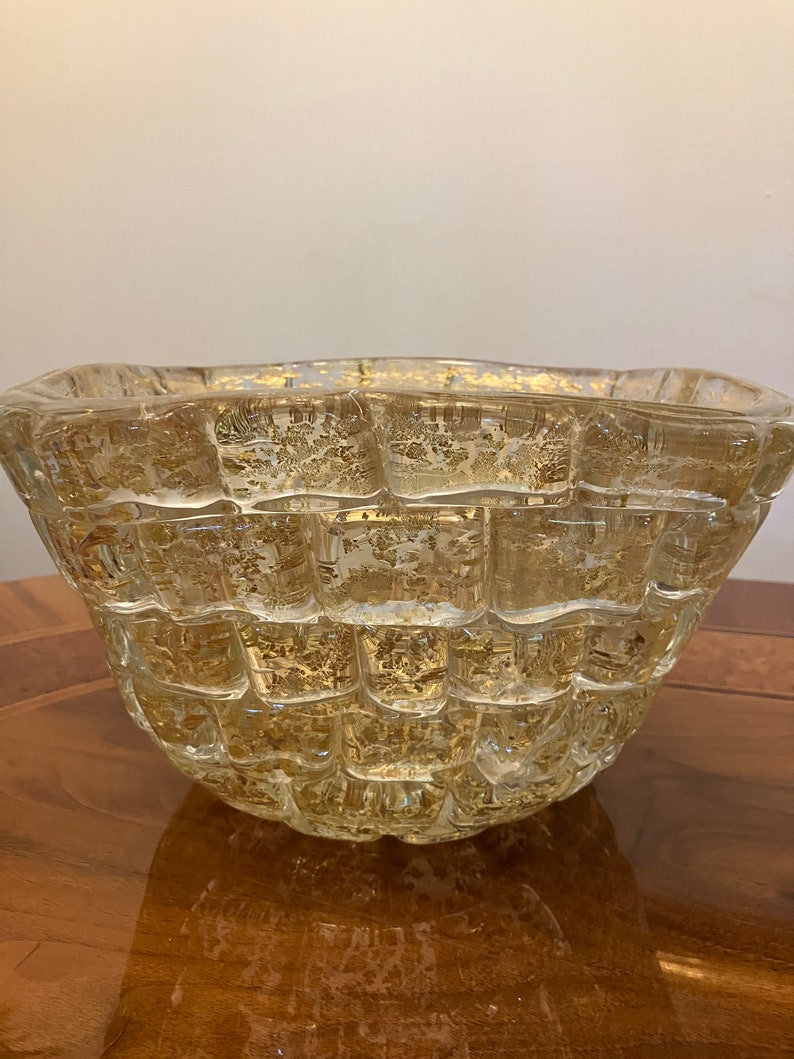 May include: A clear glass bowl with a textured, woven design. The bowl has a gold-colored metallic finish on the inside.