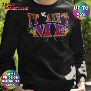 May include: Black sweatshirt with the text "It Ain't Me" in colorful letters with a flower design. The text is in a vintage style font.