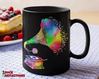 May include: Black coffee mug with a colorful watercolor illustration of a vintage gramophone. The gramophone is painted in shades of blue, green, yellow, and pink.