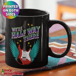 Könnte beinhalten: Schwarze Kaffeetasse mit einer weißen E-Gitarre mit Flügeln und dem Text "We're Half Way There" darauf gedruckt.