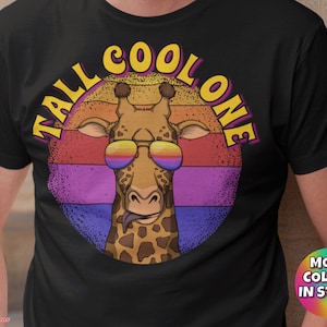 May include: Black t-shirt featuring a colourful graphic of a giraffe wearing sunglasses and the text "Tall Cool One".