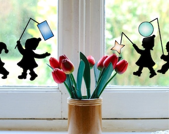 Peut inclure: Un vase en bois contient un bouquet de tulipes rouges avec des feuilles vertes, posé sur un rebord de fenêtre. Des silhouettes d'enfants avec des lanternes sont sur la fenêtre. Le vase est cylindrique et a une finition en bois naturel.
