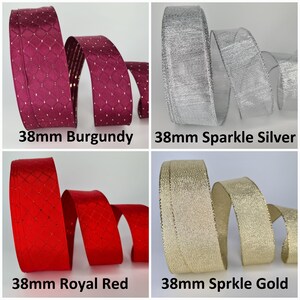 Op de afbeelding: Vier rollen van 38 mm breed lint, elk met een andere kleur en textuur. De linten zijn bordeauxrood met een ruitpatroon, zilver met een glinsterende afwerking, rood met een ruitpatroon en goud met een glinsterende afwerking.