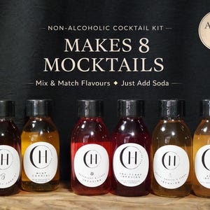 May include: A non-alcoholic cocktail kit with six small bottles of flavored syrups. The bottles have black caps and white labels with a logo. The text on the image reads "MAKES 8 MOCKTAILS" and "Alcohol Free".
