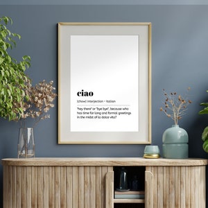 May include: A framed print with a white background and black text. The text defines the Italian word "ciao" as an interjection meaning "hey there" or "bye bye".