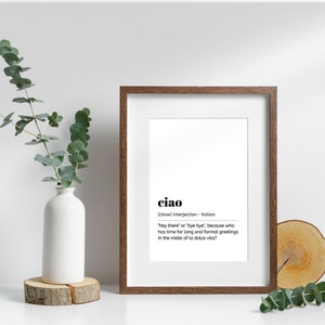 May include: A framed print with a white background and black text. The text reads "ciao" and defines the word as an Italian interjection meaning "hey there" or "bye bye".