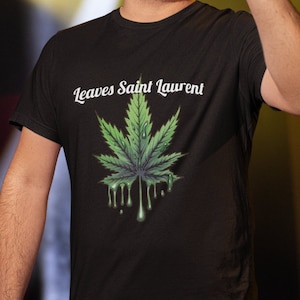 May include: Black t-shirt with a green marijuana leaf graphic and the text "Leaves Saint Laurent" in white.