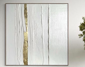 May include: A contemporary living room with a white sofa, a textured white coffee table, and an abstract painting. The painting features a white background with a gold vertical stripe. A potted tree adds a natural element.