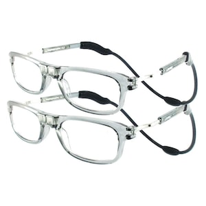 Puede incluir: Dos pares de gafas de lectura de plástico transparente con correas elásticas negras. Las gafas tienen un marco rectangular y están diseñadas para usarse sobre otras gafas.