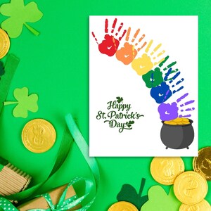 May include: A white card with a rainbow made of handprints and a pot of gold at the end. The card says "Happy St. Patrick's Day".