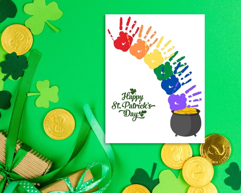 May include: A white card with a rainbow made of handprints and a pot of gold at the end. The card says "Happy St. Patrick's Day".