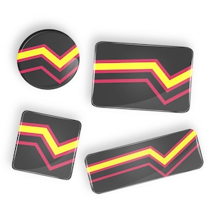 Peut inclure: Quatre boutons de différentes tailles en noir, jaune et rose avec un motif en chevron. Les boutons sont brillants et ont un effet 3D.
