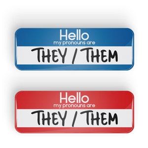 May include: Two name tags, one blue and one red, with the text "Hello, my pronouns are THEY/THEM" on each.