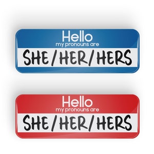 May include: Two name tags, one blue and one red, with the text "Hello my pronouns are SHE/HER/HERS" on each.