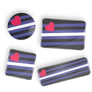 Peut inclure: Quatre boutons de différentes tailles avec un motif rayé noir et bleu, une bande blanche et un cœur rose. Les boutons sont en matériau brillant.