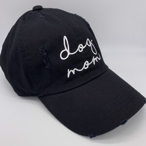 May include: A black baseball cap with a white embroidered design that says "dog mom".