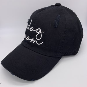 May include: Black baseball cap with a white embroidered inscription that reads "Dog Mom".