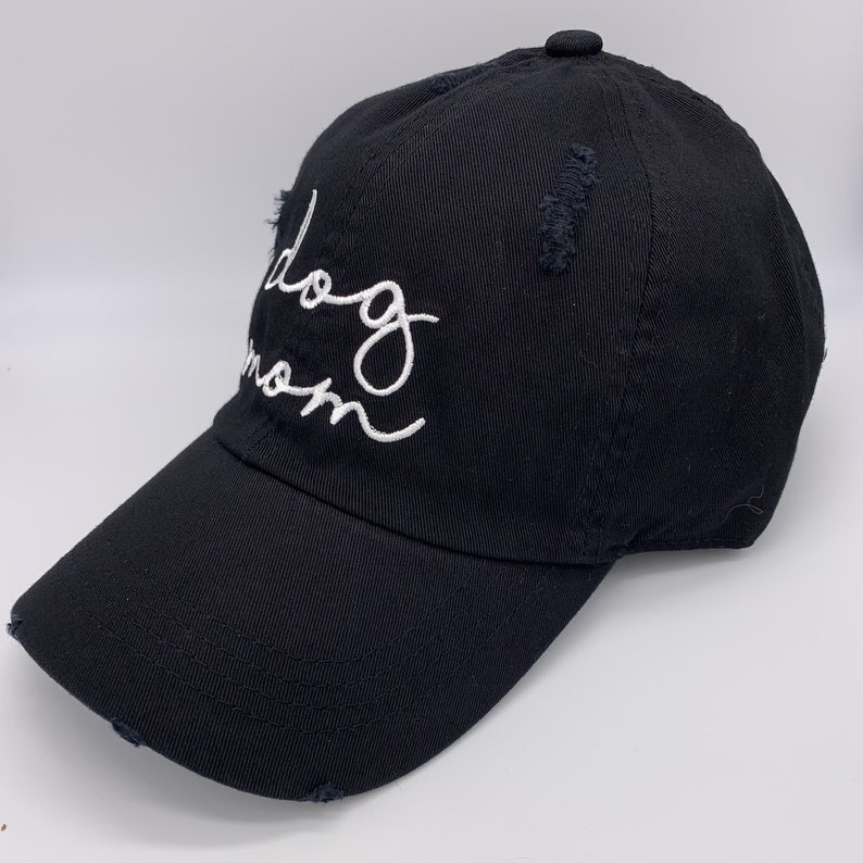 May include: Black baseball cap with a white embroidered inscription that reads "Dog Mom".
