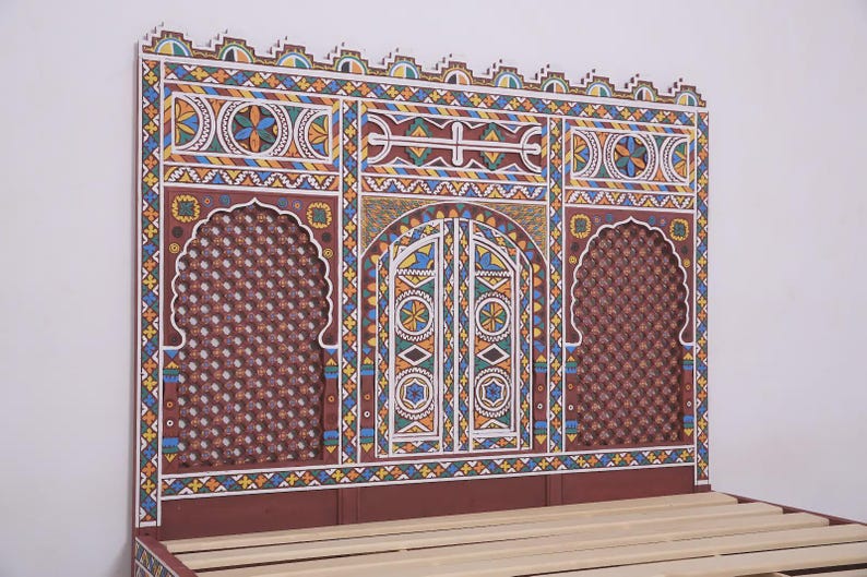 May include: A hand-painted headboard with a vibrant geometric design. The headboard features a central arched door design and two arched windows. The color scheme includes red, blue, yellow, and white. The bed frame is visible at the bottom.
