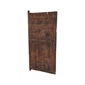 May include: A wooden door with intricate carvings and painted details. The door is brown with blue, yellow, and orange accents. The door has a metal handle and hinges.
