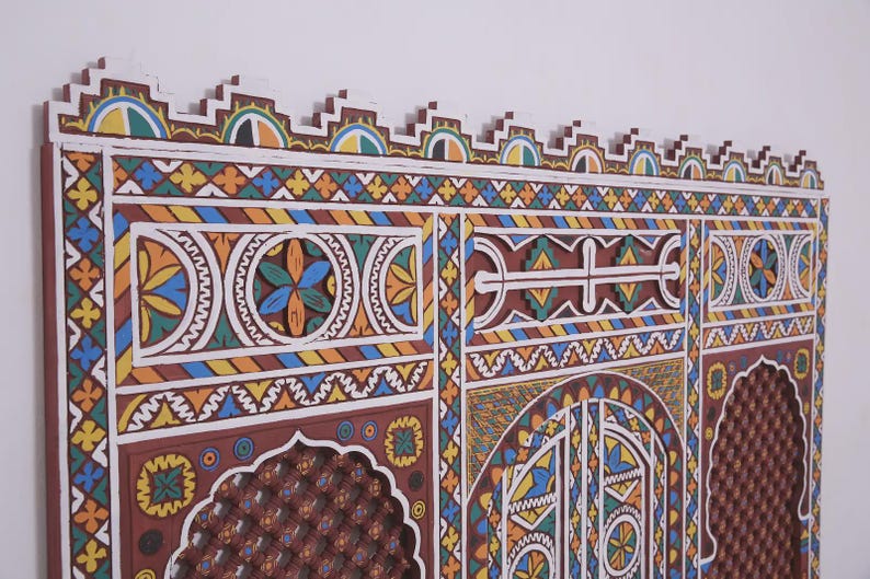 May include: A detailed, hand-carved wooden panel with a vibrant geometric design. The artwork incorporates a range of colours, such as blue, yellow, orange, and white. The panel has a decorative top edge and a dark brown background, with measurements in cm.