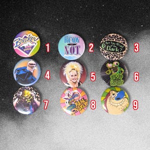 May include: A collection of nine circular pin-back buttons featuring various pop culture graphics. Designs include Breaker High, Ready or Not, Are You Afraid of the Dark, a blue creature, a blonde person, Bump in the Night, a monster, Real Monsters, and Ren.