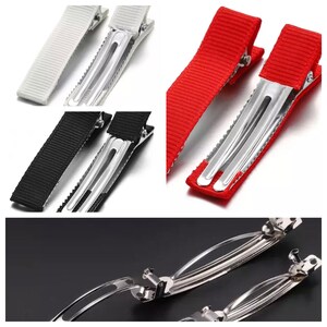 May include: Set of hair clips with metal clips and fabric covered ends. The clips are available in black, white, and red.