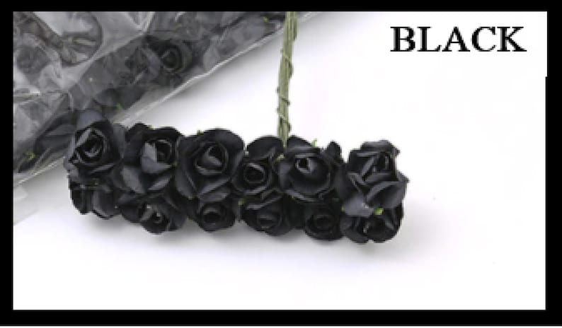 Puede incluir: Un ramo de peque&ntilde;as rosas de papel negro con tallos verdes. Las rosas est&aacute;n dispuestas en c&iacute;rculo y est&aacute;n atadas con una cinta verde. Las rosas est&aacute;n sobre un fondo blanco. BLACK est&aacute; escrito en texto negro sobre un fondo blanco.
