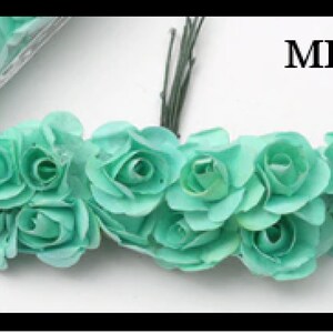 Puede incluir: Un racimo de rosas de papel verde menta con tallos alambrados. MINT est&aacute; escrito en texto negro sobre un fondo blanco.