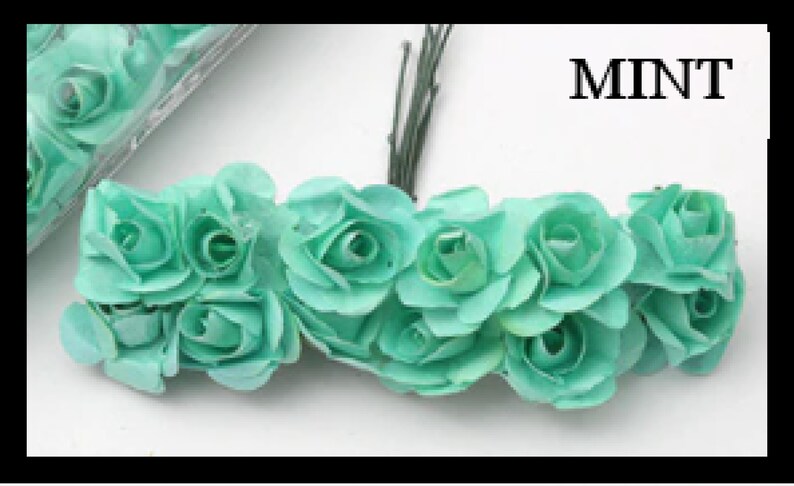 Puede incluir: Un racimo de rosas de papel verde menta con tallos alambrados. MINT est&aacute; escrito en texto negro sobre un fondo blanco.