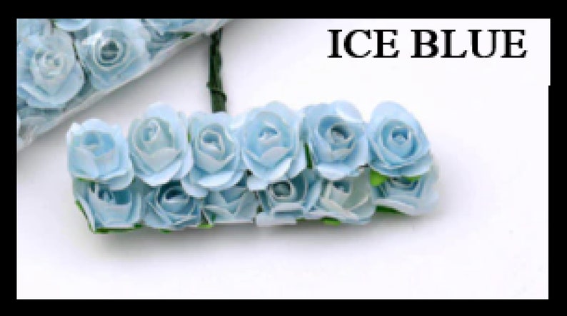 Puede incluir: Un grupo de rosas de papel azul claro con tallos verdes. Las rosas est&aacute;n dispuestas en fila y todas miran en la misma direcci&oacute;n. El texto "ICE BLUE" est&aacute; escrito en letras negras en la parte superior de la imagen.