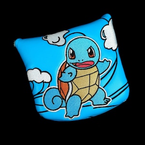 May include: A blue golf club headcover with an embroidered Squirtle design. The cover has a light blue background with white clouds and black outlines. The Squirtle character is blue, with a tan shell and red mouth.