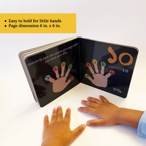 Puede incluir: Un libro infantil en blanco y negro con una huella de mano colorida en cada p&aacute;gina. El libro est&aacute; abierto en una p&aacute;gina con el n&uacute;mero 10 y la palabra "dawsh" escrita en una fuente colorida. El texto en la p&aacute;gina dice: "সোনামণি কি বলতে পারে আমাদের দুহাতে আঙ্গুল কয়টি? এসো আমরা গুনতে থাকি... 2 3 8 7 8 10 [dawsh] 10 দশটি". El libro mide 15,24 cm por 15,24 cm.