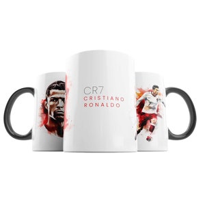 May include: White ceramic mug with a black handle. The mug features a watercolour illustration of Cristiano Ronaldo, a football player, with the text "CR7 CRISTIANO RONALDO" printed on the front.