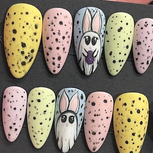 May include: Set of ten false nails with a pastel color scheme.  The nails feature a polka dot pattern and a bunny rabbit design.