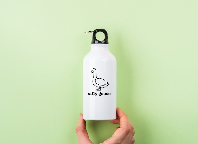 May include: White water bottle with a black lid and a black and white illustration of a goose with the text "silly goose" printed on the front.
