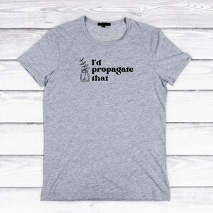 Peut inclure: Un t-shirt gris avec le texte "I'd propagate that" et un dessin d'une plante dans un bocal.