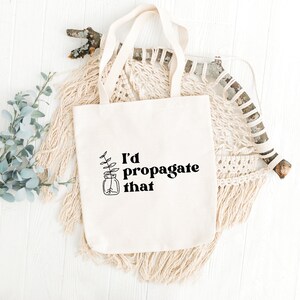 Peut inclure: Un sac fourre-tout en toile blanche avec le texte "I'd propagate that" et un dessin simple d'une plante dans un bocal.
