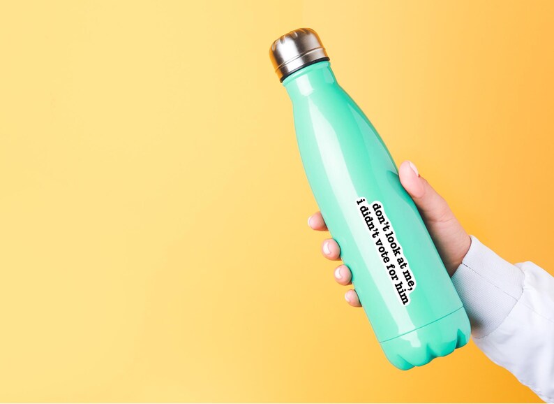 K&ouml;nnte beinhalten: Eine t&uuml;rkisfarbene wiederverwendbare Wasserflasche mit einem wei&szlig;en Aufkleber, auf dem steht: "Schau mich nicht an, ich habe nicht f&uuml;r ihn gestimmt"