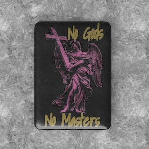 Könnte beinhalten: Schwarzer quadratischer Pin mit einem rosa Engel, der ein Kreuz hält. Der Text "No Gods No Masters" ist in goldenen Buchstaben geschrieben.
