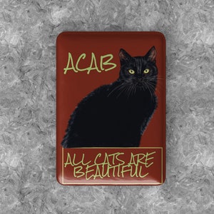 May include: A red rectangular magnet featuring a black cat image and the text "ACAB ALL CATS ARE BEAUTIFUL" in green.