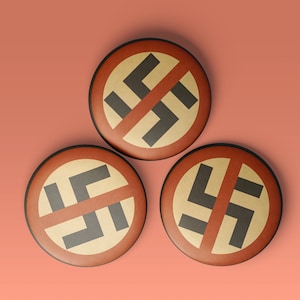 May include: Three round buttons with a red background and a black swastika symbol with a red line through it. The buttons are arranged in a triangular shape.