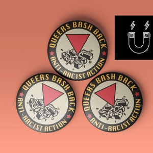 Könnte beinhalten: Drei runde Buttons mit dem Text "QUEERS BASH BACK" und "ANTI-RACIST ACTION". Jeder Button zeigt ein rotes Dreieck und eine Grafik von zerbrochenen Ziegeln. Ein schwarzes Quadrat mit einer Magnetillustration befindet sich oben rechts.