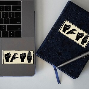 Close-up of ACAB hand signs vinyl sticker texture showing fine matte laminated finish.