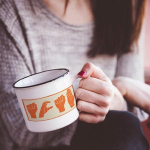 ACAB hand signs sticker on white mug – activism design made with care and empathy.
