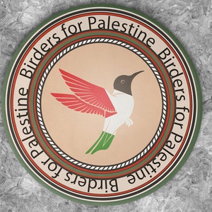 Może przedstawiać: Okrągła odznaka z napisem "Palestine Birders for Palestine" otaczającym ilustrację kolibra. Ptak ma czerwone skrzydła, białe ciało i zielone nogi. Odznaka jest umieszczona na teksturowanym szarym tle.