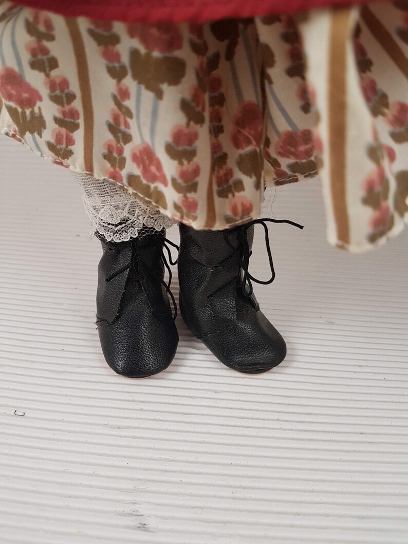 Puede incluir: Un par de botas de cuero negro con cordones y punta redonda. Las botas est&aacute;n gastadas y tienen un aspecto vintage.