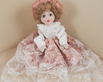 vintage old porcelain doll handpainted face pink dressed
