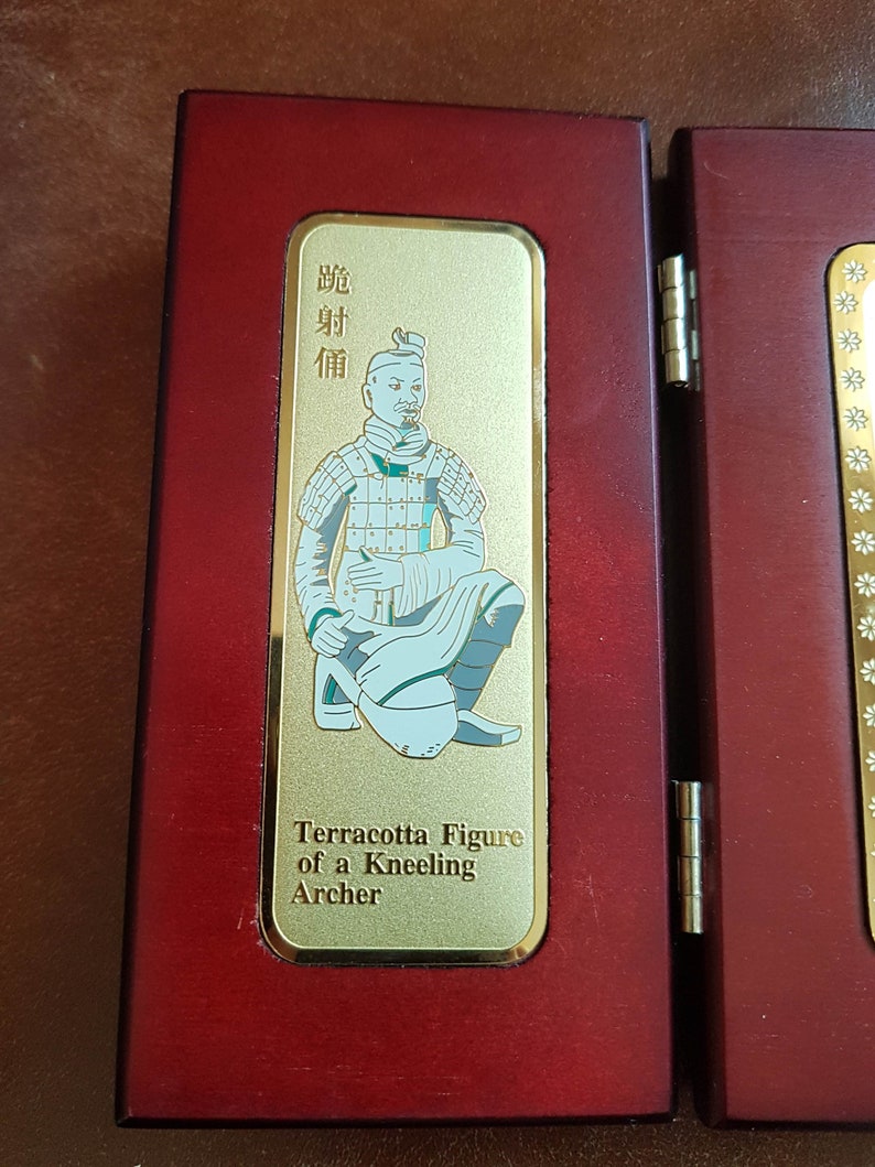 May include: A wooden display case with a gold plaque featuring a terracotta figure of a kneeling archer. The plaque has the text "Terracotta Figure of a Kneeling Archer" and Chinese characters in gold.
